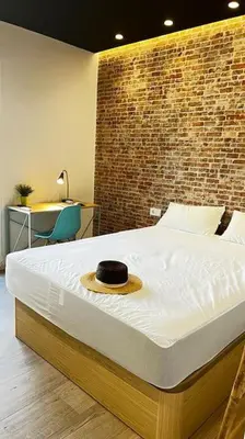 a bedroom with a bed with a hat on it at Beach Valencia Rooms Late Checkout 14 h free Netflix Tv in Valencia