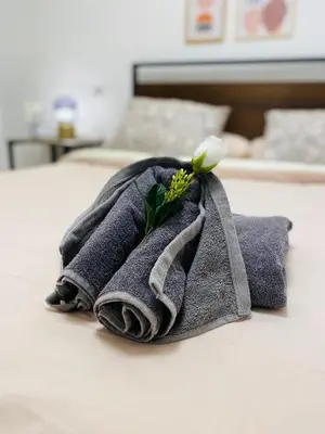 a towel with a flower on top of a bed at BatFlats - RUZAFA in Valencia