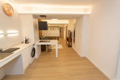 a kitchen and living room with white walls and wooden floors at BatFlats - RUZAFA in Valencia