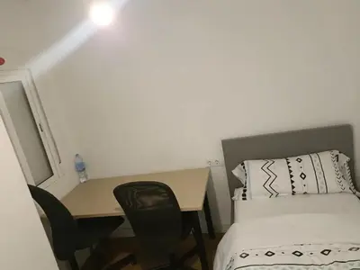 a small room with a bed and a desk and a bed at habitaciones patraix in Valencia