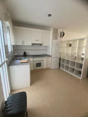 a kitchen with white cabinets and a white refrigerator at Pericos Gilet in Gilet