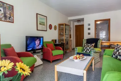 a living room with green and red chairs and a tv at Valencia Flat Rental Patacona Beach in Valencia