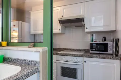 a kitchen with white cabinets and a stove top oven at Valencia Flat Rental Patacona Beach in Valencia
