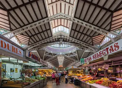 a market with people walking through a market with fruits and vegetables at Valencia Old Town Suite in Valencia