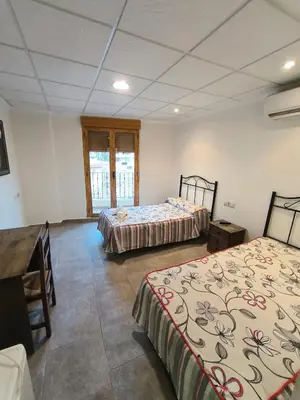 a room with two beds and a desk in it at Ca' La Conchin in Cortez de Pallas