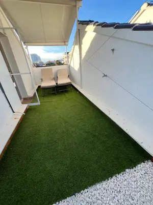 a room with two chairs and green carpet at MAGNÍFICO ADOSADO CERCA DEL MAR in Canet de Berenguer