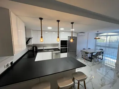 a kitchen with a black counter top and a table at MAGNÍFICO ADOSADO CERCA DEL MAR in Canet de Berenguer