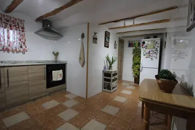 a kitchen with a refrigerator and a table in it at Casa de pueblo en Calles in Calles