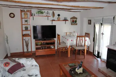 a living room with a tv and a table at Casa de pueblo en Calles in Calles