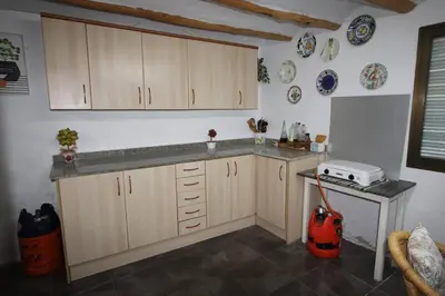 a kitchen with a counter and a refrigerator at Casa de pueblo en Calles in Calles