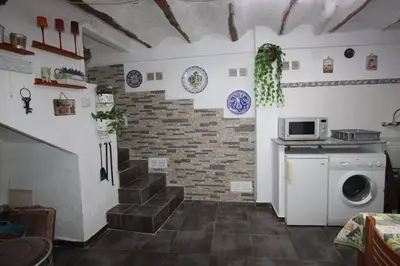 a laundry room with a staircase and a microwave at Casa de pueblo en Calles in Calles
