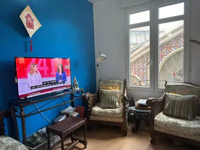 a living room with two chairs and a flat screen tv at Mirador 1 del Mercado Central - habitacion con baño privado en el centro de la Ciudad Vella in Valencia