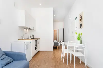 a kitchen and a living room with a table and chairs at SOROLLA APARTMENTS CENTRAL Station in Valencia