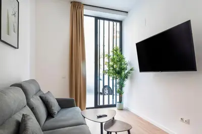 a living room with a couch and a large window at SOROLLA APARTMENTS CENTRAL Station in Valencia