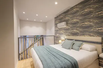 a bedroom with a large bed with a wall at FLORIT FLATS - The Mediterranean Suites in Valencia