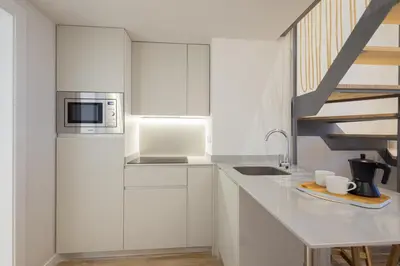 a white kitchen with a sink and a microwave at FLORIT FLATS - The Mediterranean Suites in Valencia
