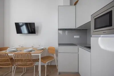 a kitchen with a table with chairs and a microwave at FLORIT FLATS - The Mediterranean Suites in Valencia