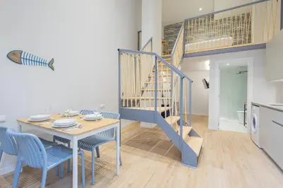a dining room with a table and a blue staircase at FLORIT FLATS - The Mediterranean Suites in Valencia