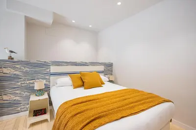 a bedroom with a bed with a yellow blanket at FLORIT FLATS - The Mediterranean Suites in Valencia