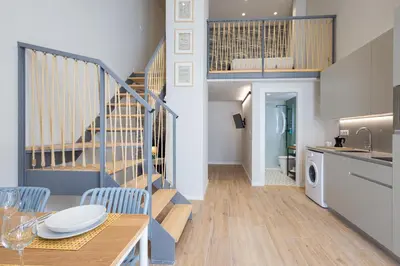 a kitchen and dining room with a staircase in a house at FLORIT FLATS - The Mediterranean Suites in Valencia