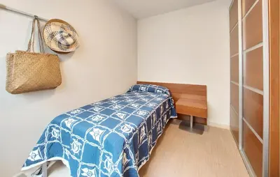 a bedroom with a bed with a blue and white blanket at 2 Bedroom Awesome Apartment In Moncofa in Moncófar