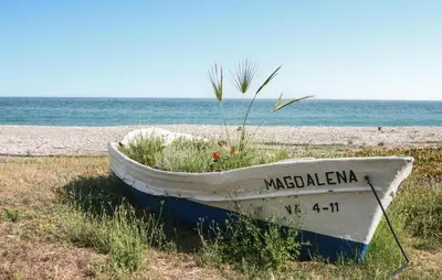 a boat sitting on the shore of a beach at 2 Bedroom Awesome Apartment In Moncofa in Moncófar