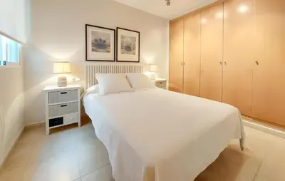a bedroom with a large white bed and a night stand at 2 Bedroom Awesome Apartment In Moncofa in Moncófar
