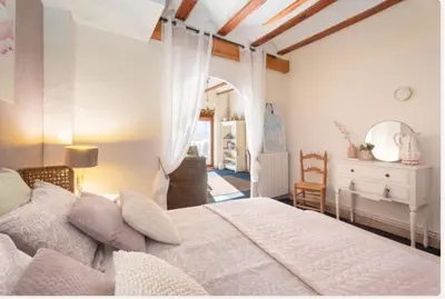 a bedroom with a large white bed and a desk at Ensueño Alojamiento Turístico in Alcublas
