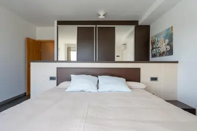 a bedroom with a large bed with white sheets at Descubre Villa Oasis - Confort, diseño y naturaleza a un paso de Valencia in Chiva