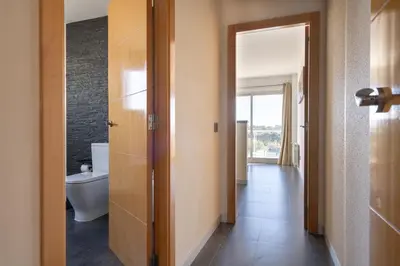 a bathroom with a toilet and a door to a hallway at Descubre Villa Oasis - Confort, diseño y naturaleza a un paso de Valencia in Chiva