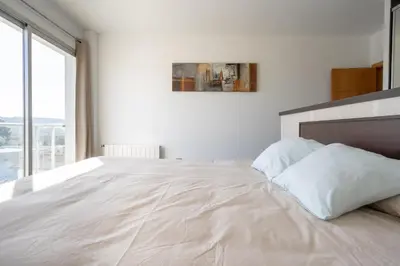 a white bedroom with a large bed and a window at Descubre Villa Oasis - Confort, diseño y naturaleza a un paso de Valencia in Chiva