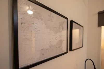 a framed map hanging on a wall next to a mirror at FLORIT FLATS - The Pitiusas Rooms in Valencia