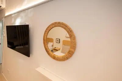 a mirror on a white wall with a tv at FLORIT FLATS - The Pitiusas Rooms in Valencia