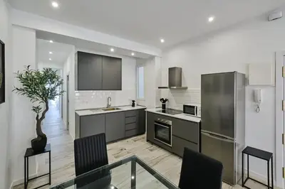 a kitchen with stainless steel appliances and a table and chairs at Arenas flat in Valencia