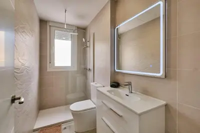 a bathroom with a sink and a toilet and a mirror at Arenas flat in Valencia