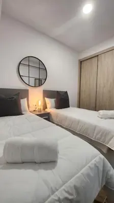 a bedroom with two white beds and a mirror at Casa Valencia al mar in Valencia