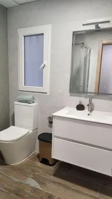 a bathroom with a toilet and a sink and a mirror at Casa Valencia al mar in Valencia