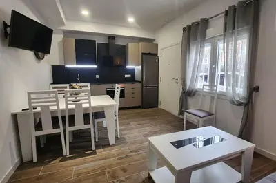 a living room with a table and a kitchen at Casa Valencia al mar in Valencia