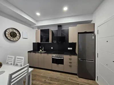 a kitchen with a black refrigerator and a table at Casa Valencia al mar in Valencia