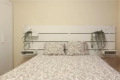 a bedroom with a bed with a white headboard at Non Stress Nuevo Turia in Valencia