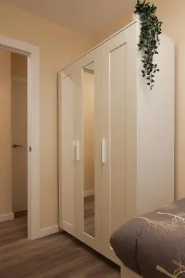 a bedroom with a large white cabinet with a mirror at Non Stress Nuevo Turia in Valencia