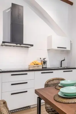 a kitchen with a wooden table and a sink at Cabanyal Sunny Beach House in Valencia