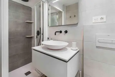 a white bathroom with a sink and a mirror at Cabanyal Sunny Beach House in Valencia