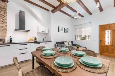 a kitchen with a table with plates and wine glasses at Cabanyal Sunny Beach House in Valencia