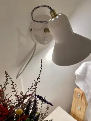 a white lamp hanging on a wall with flowers at Cabanyal Sunny Beach House in Valencia