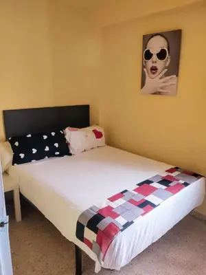 a bedroom with a bed with a woman wearing sunglasses at Habitación en la playa in Valencia