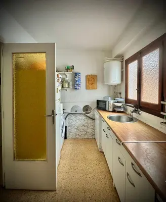 a kitchen with a door open to a kitchen with a sink at Habitación en la playa in Valencia