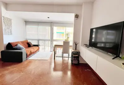 a living room with a couch and a large flat screen tv at ACOGEDOR PISO EN CULLERA JUNTO AL MAR in Cullera