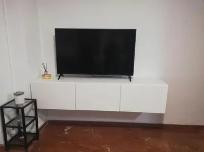 a flat screen tv sitting on top of a white cabinet at ACOGEDOR PISO EN CULLERA JUNTO AL MAR in Cullera