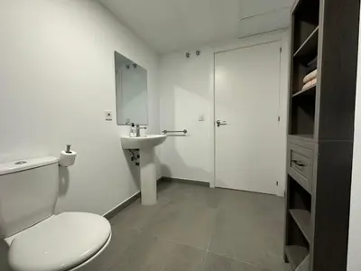 a white bathroom with a toilet and a sink at Apartamentos Canet al Mar. in Canet de Berenguer
